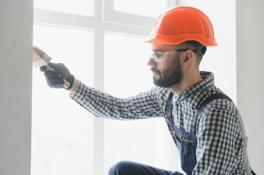 Fırça boyama ahşap çit üzerinde beyaz holding işçi el.