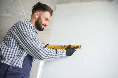 Gri beton duvarın arkasında gülen inşaat işçisi. Yenileme. metin için yer.