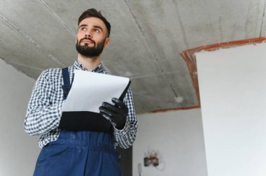 İnşaat sürecinde apartman malzemeleri için hesaplamalar yapan kendini işine adamış bir işçi