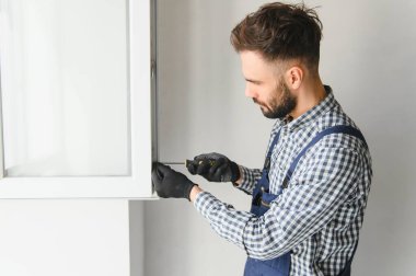 İçeriye plastik pencere kuran işçiler.