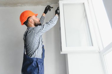 Ev üzerine beyaz plastik upvc pencere kurma işçisi