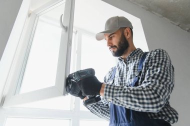 servis elemanı tornavidayla pencere kuruyor.