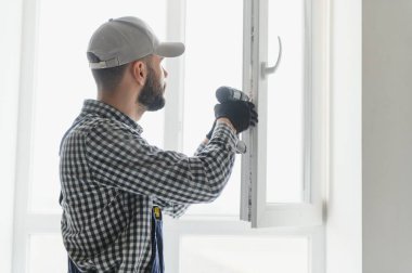 servis elemanı tornavidayla pencere kuruyor.