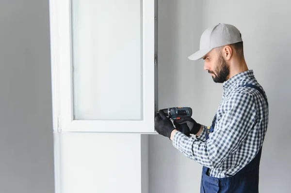 stock image Construction worker installing window in house.