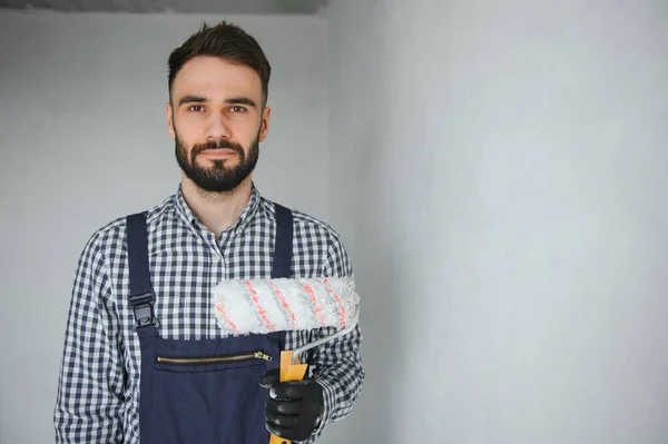 Junger Lächelnder Facharbeiter Blauer Uniform Steht Mit Farbroller Neuer Wohnung — Stockfoto