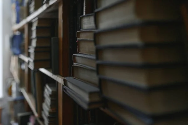 stock image old books on shelves in archive blurred image, library.