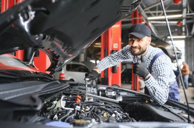Araba tamir garaja Kaputunun altında mekanik incelenmesi.