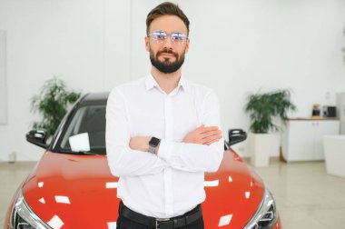 Yeni lüks arabaları kontrol eden, galeriden otomobil alan mutlu bir genç. Galeride otomobili inceleyen bin yıllık beyaz bir adamın portresi..