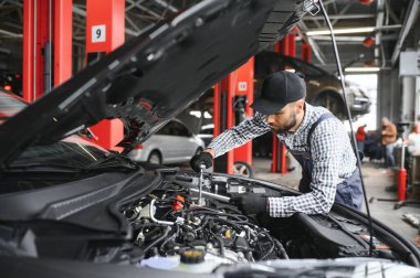 Araba tamir garaja Kaputunun altında mekanik incelenmesi.