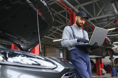 Otomobil tamir servisinde çalışan profesyonel araba tamircisi.