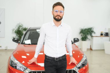 Yeni lüks arabaları kontrol eden, galeriden otomobil alan mutlu bir genç. Galeride otomobili inceleyen bin yıllık beyaz bir adamın portresi..