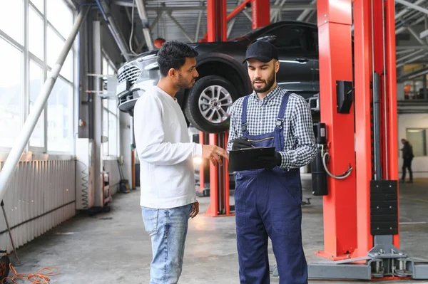 一位汽车修理工正在和一位印度车主交谈 汽车服务概念 — 图库照片