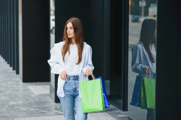 美丽的年轻女子 与户外店附近的购物袋 — 图库照片