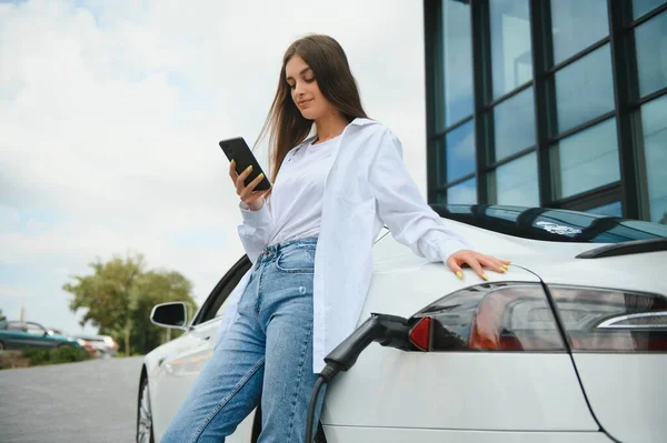 stock image girl charging electro car at the electric gas station.