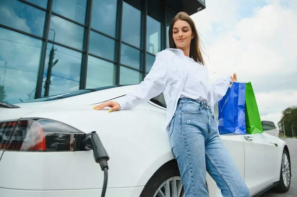 stock image girl charging electro car at the electric gas station.