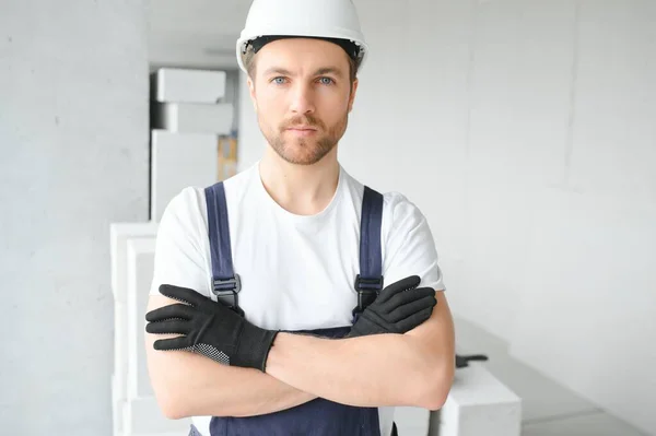 一名身穿制服的年轻工头站在建筑工地靠近梯子的画像 — 图库照片