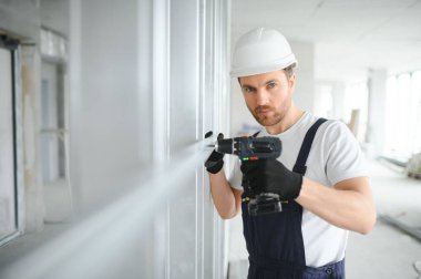 Alçıpan işçisi bir evin inşaat alanında çalışıyor.