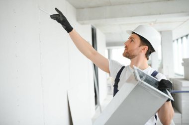 Alüminyum İskeledeki Profesyonel HVAC İşçisi Yeni Yapılmış Ticari Binanın içine Hava Kanalı Kuruyor. Endüstriyel Tema.