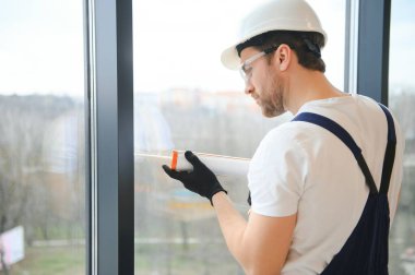 İnşaat işçisi eve pencere kuruyor