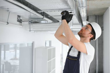 Havalandırma sistemi kurulum ve onarım servisi. HVC teknisyeni iş başında. afiş kopyalama alanı.