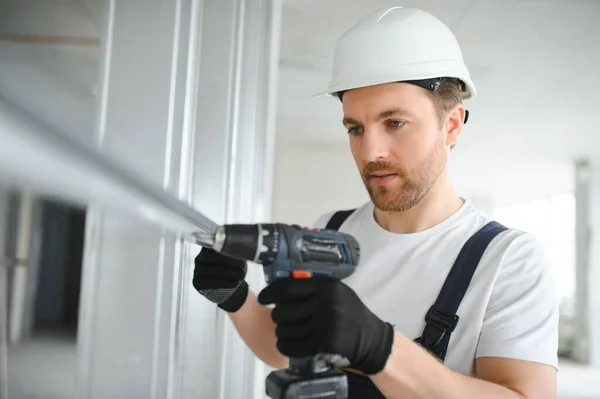 drywall worker works on building site in a house