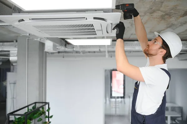 Young Repairman Repairing Ceiling Air Conditioning Unit — Stock Photo, Image