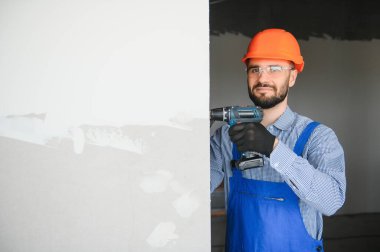 İşçiler alçıdan bir duvar örüyor