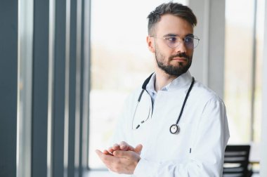 Hastanede mutlu erkek doktor portresi.