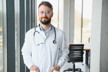 Hastanede mutlu erkek doktor portresi.