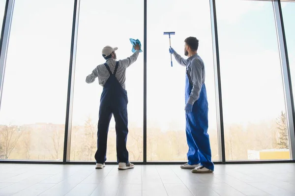 一个男人在擦窗户清洁组的人洗刷窗户 — 图库照片
