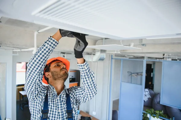 屋内で現代のエアコンを維持する専門の技術者 テキスト用のスペース — ストック写真