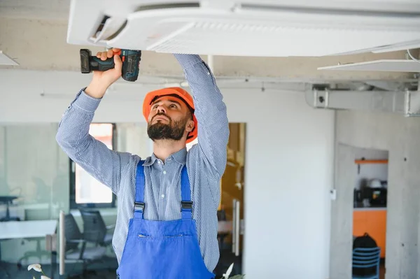 屋内のエアコンの点検と修理を行う技術者サービス — ストック写真
