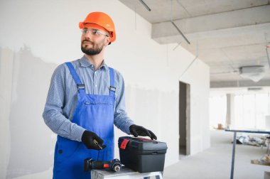 İnşaat alanında alet çantalı bir inşaatçı.