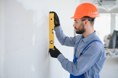 İşçiler alçıdan bir duvar örüyor