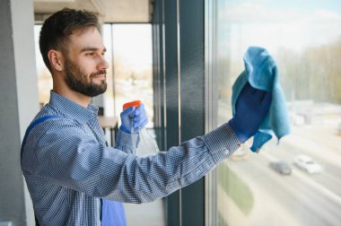 Erkek işçi cam yıkıyor.