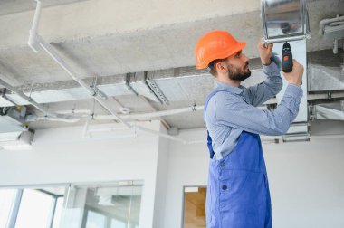 HVC işçisi havalandırma ve havalandırma için boru sistemi kuruyor. Boşluğu kopyala.