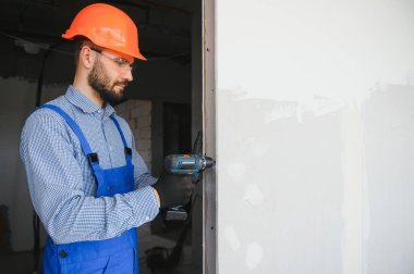 İşçiler alçıdan bir duvar örüyor