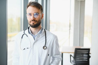 Hastanede mutlu erkek doktor portresi.