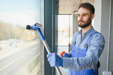 Erkek işçi cam yıkıyor.