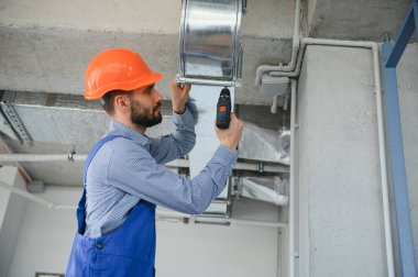 Havalandırma sistemi kurulum ve onarım servisi. HVC teknisyeni iş başında. afiş kopyalama alanı