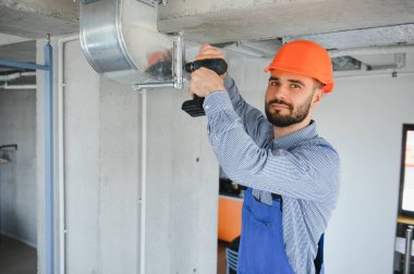 HVC işçisi havalandırma ve havalandırma için boru sistemi kuruyor. Boşluğu kopyala.