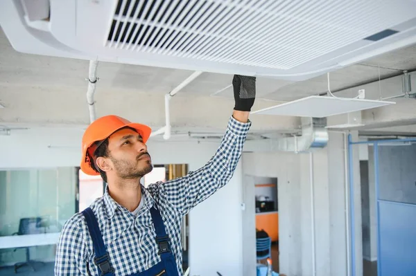 屋内で現代のエアコンを維持する専門の技術者 テキスト用のスペース — ストック写真