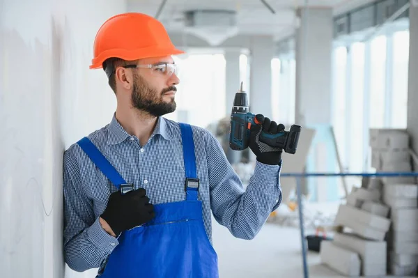 在建筑工地工作时戴硬礼帽的积极英俊年轻男性建筑工人的画像 — 图库照片