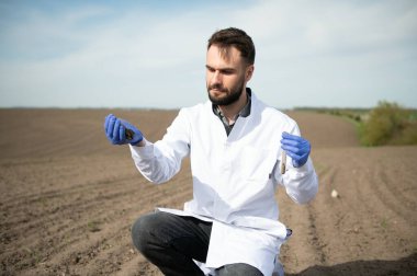 Toprak testi. Tarım Uzmanı doğurganlık analizi için toprak örneği alıyor. Eldivenli eller, yaklaşın. Çevre koruma, organik toprak sertifikası, saha çalışması, araştırma