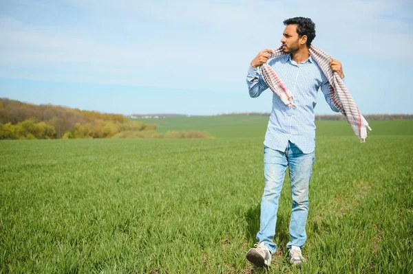 stock image worry less ,indian farmer standing in his healthy wheat field.