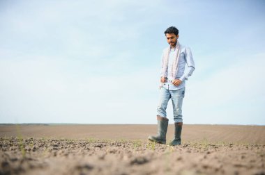 Genç bir Hintli çiftçi ekmeden önce tarlasını kontrol eder.