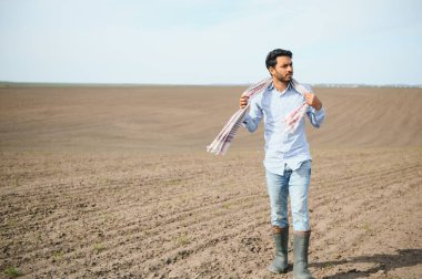 Genç bir Hintli çiftçi ekmeden önce tarlasını kontrol eder.