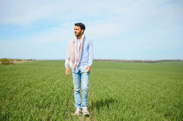 Stock image worry less ,indian farmer standing in his healthy wheat field.