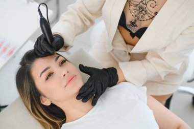 Kalıcı kaş makyajı sırasında genç bir kadın..