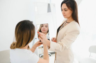 Kozmetik uzmanı kaşlarına kalıcı makyaj uyguluyor..